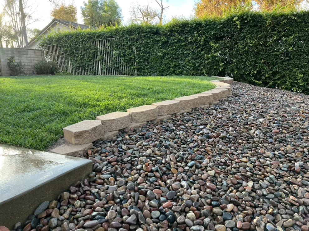 Curved lawn, river-rock bed and established hedges in Aran’s landscape portfolio